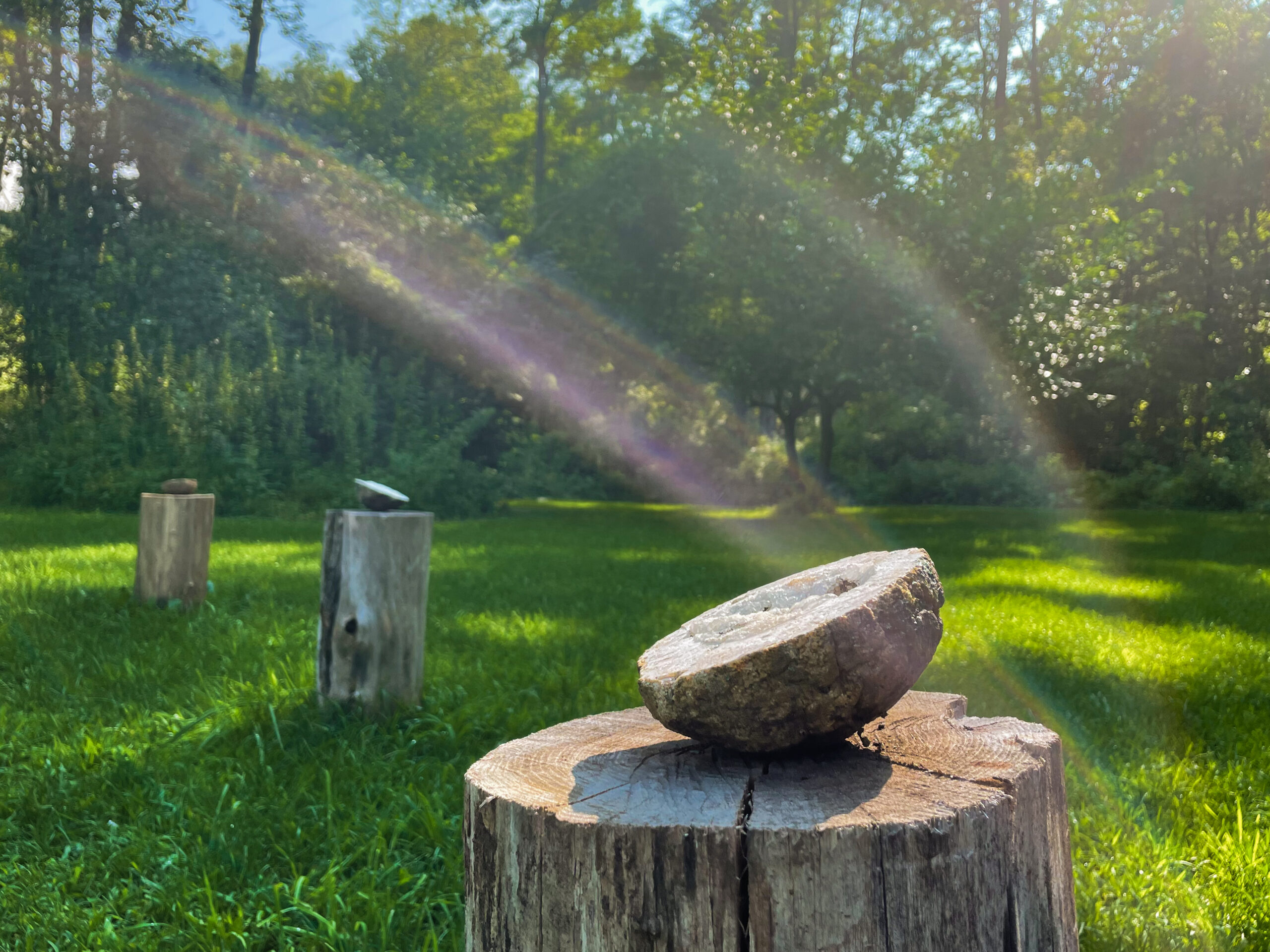 Geode sitting on a stump with light flaring around it